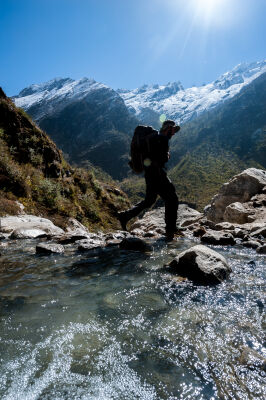 Trekker crossing stream in Langtang Trek
