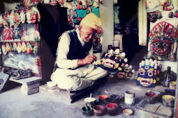 The elderly Chitrakar from Thimi is skillfully painting a traditional Nepali mask.