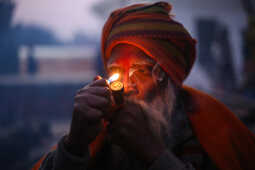 A sadhu participates in Shivaratri rituals while smoking a chillum at the Pashupatinath Temple premises, 2026.