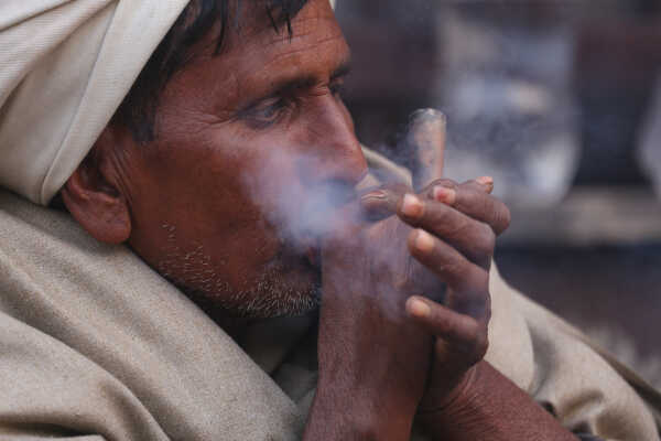 A sadhu participates in Shivaratri rituals while smoking a chillum at the Pashupatinath Temple premises, 2026.