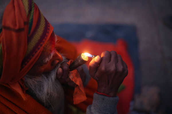 A sadhu participates in Shivaratri rituals while smoking a chillum at the Pashupatinath Temple premises, 2026.